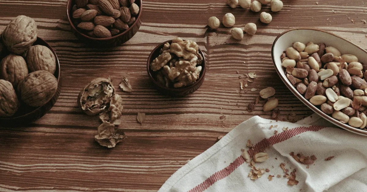 Bowls of walnuts, almonds and hazelnuts on a wooden table