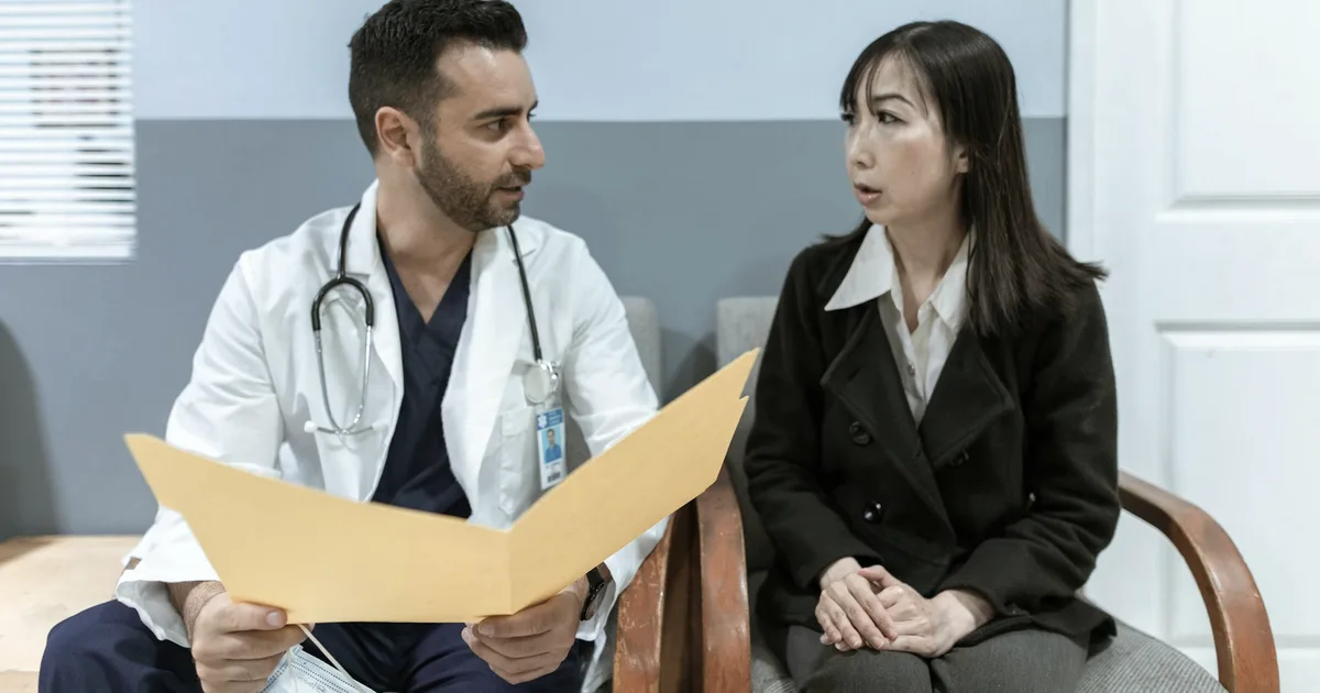 Médecin examinant un dossier avec une patiente lors d'une consultation, situation type de la démarche diagnostique décrite par Annick Vincent