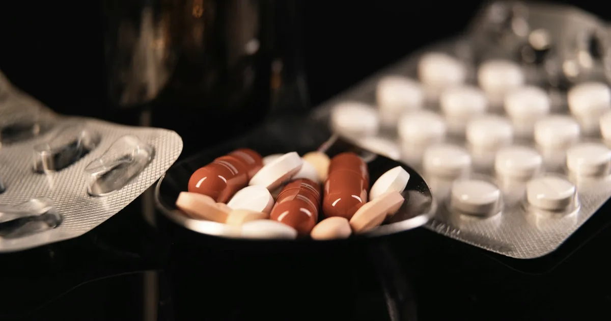 ADHD medication pills and blister packs on a dark surface