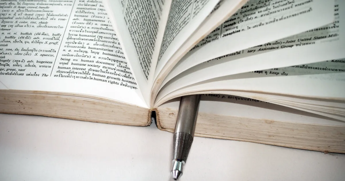 Dictionnaire ouvert avec un stylo posé entre les pages