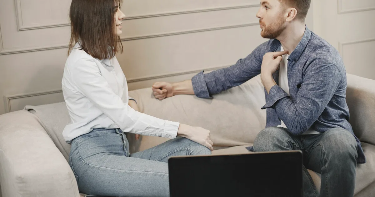 A couple sitting on a sofa, in a calm conversation