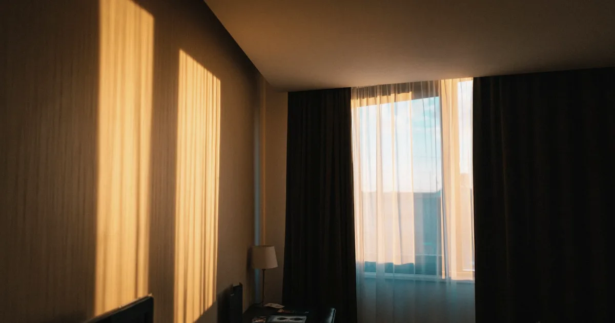 A quiet room crossed by warm light at the end of the day
