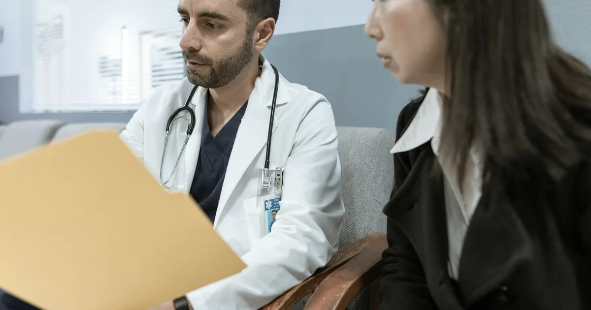 A doctor and patient reviewing a file together during a consultation